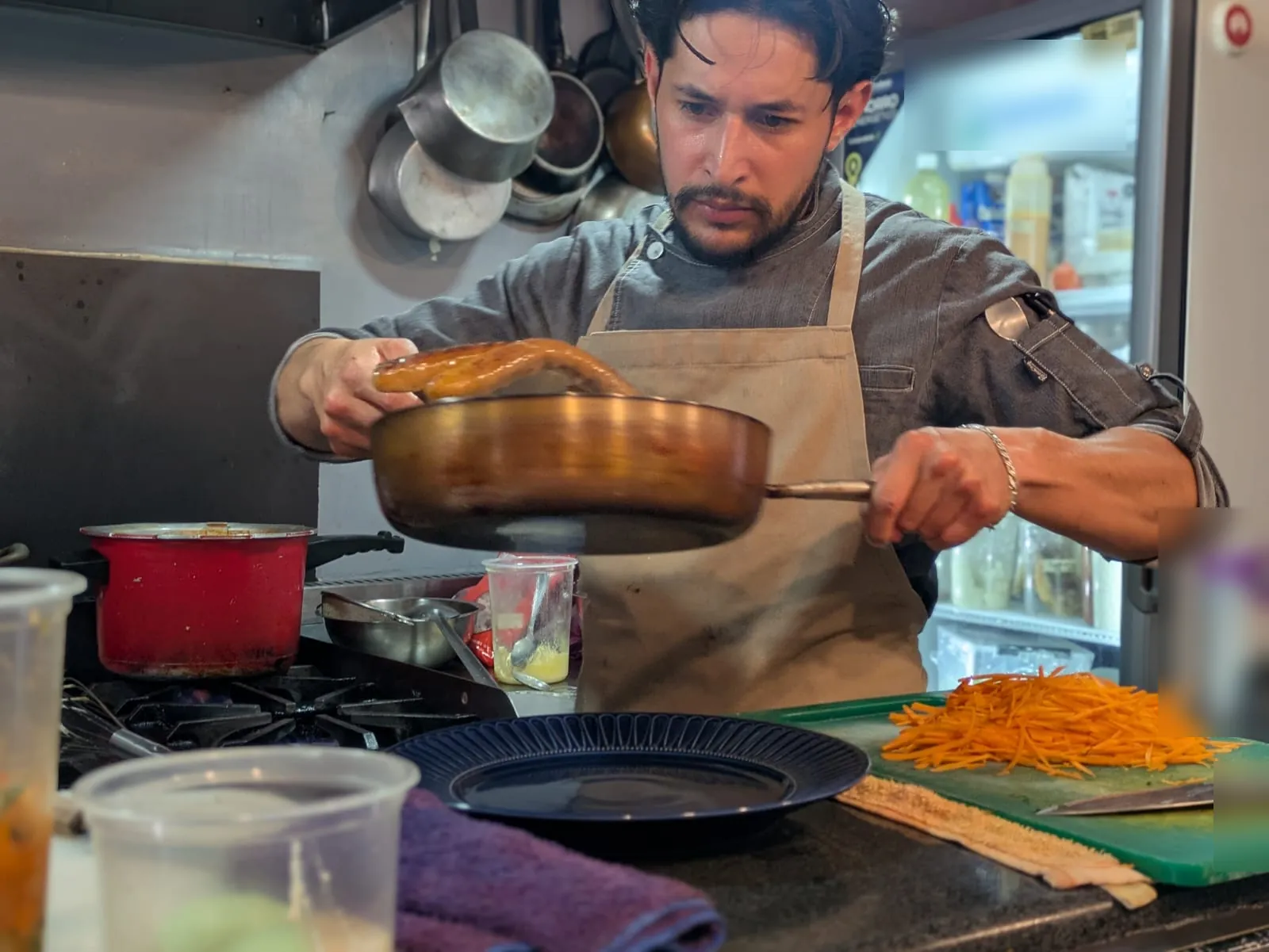 El chef Luis Alba voltea un sartén de cobre en la cocina