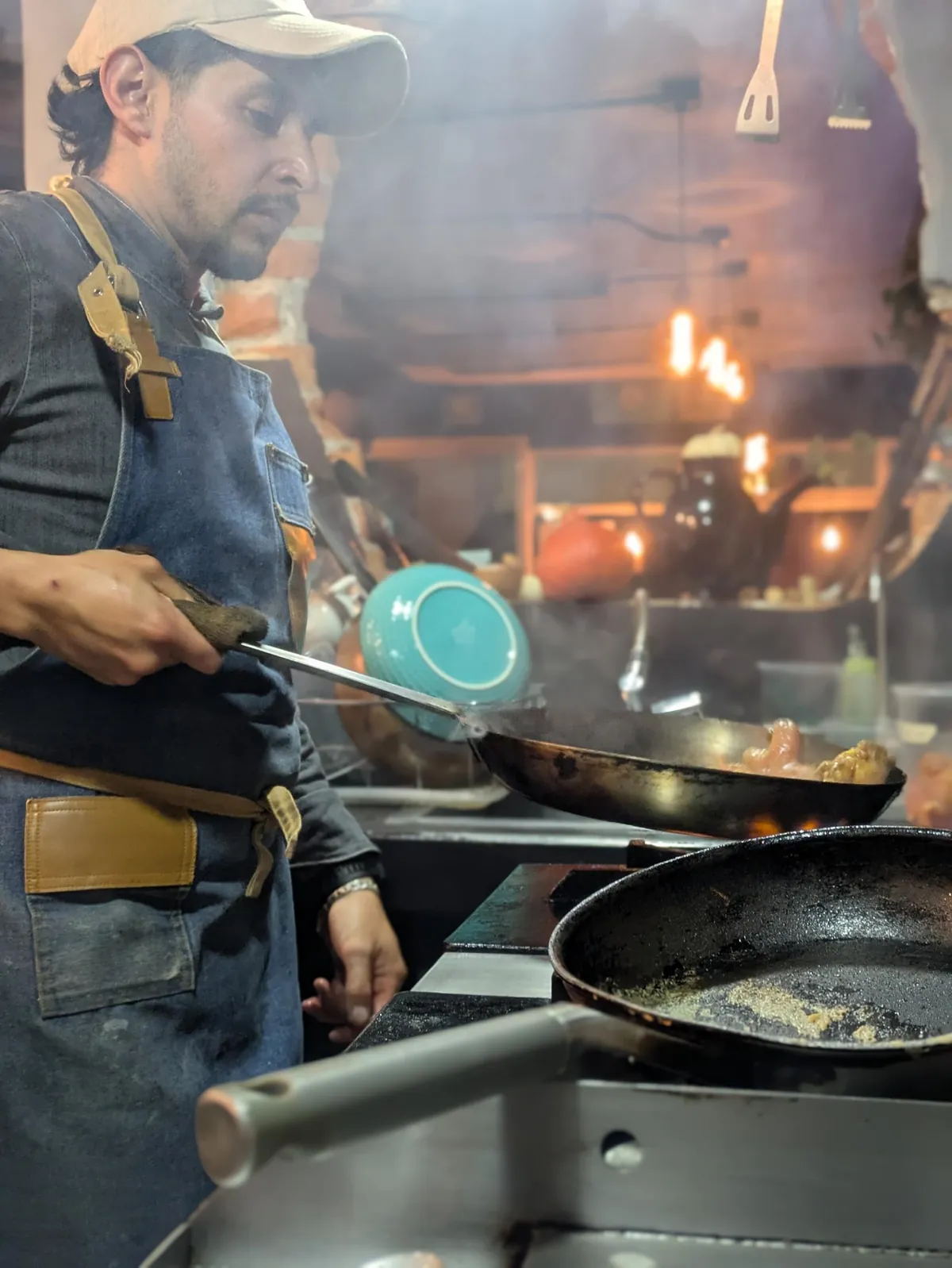 El chef Luis Alba saltea en un sartén sobre la estufa de su cocina